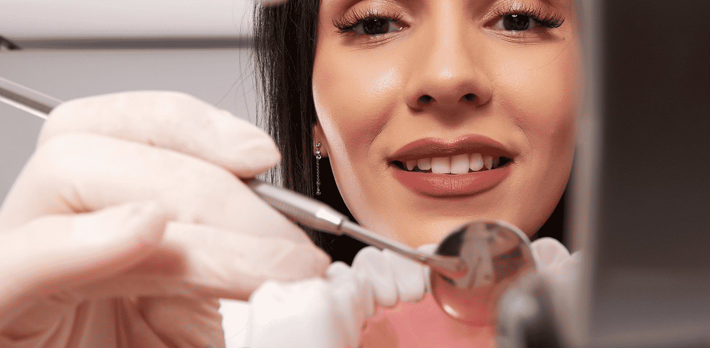 Dr Luisa examining a patient's teeth with dental tools