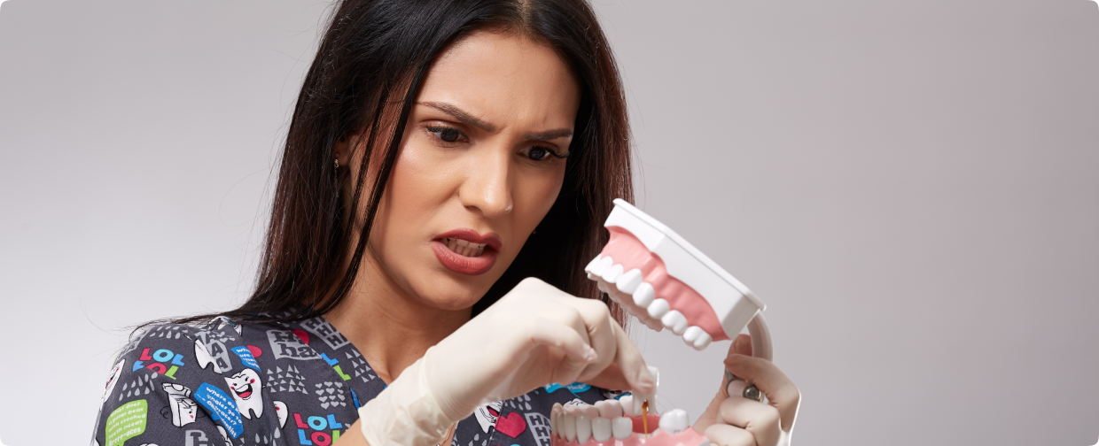 Dr Luisa examining a dental model with a focused expression